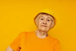 anziano donna contento stile di vita nel un' giallo copricapo avvicinamento emozioni foto