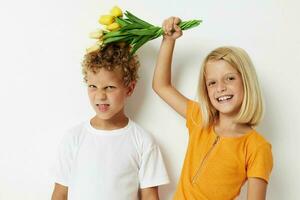 Due gioioso bambini con un' mazzo di fiori regalo compleanno vacanza infanzia leggero sfondo foto