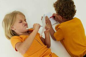 allegro bambini disegno nel i Quaderni dire bugie su il pavimento infanzia stile di vita inalterato foto