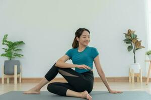 sottile donna praticante yoga su camera di sua condominio. asiatico donna fare esercizi nel mattina. equilibrio, meditazione, rilassamento, calma, bene Salute, felice, relax, salutare stile di vita, dieta, sottile foto