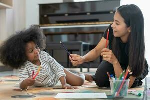 contento Asia madre apprendimento dipingere per poco ragazza. famiglia è contento e eccitato nel il Casa. madre e figlia avendo divertimento la spesa tempo insieme. vacanza, attività, esecutivo funzione, iq, eq foto