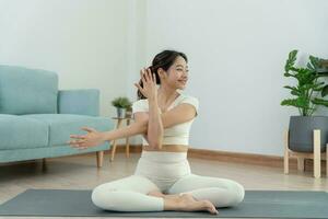 sottile donna praticante yoga su camera di sua condominio o casa. asiatico donna fare esercizi nel mattina. equilibrio, meditazione, rilassamento, calma, bene Salute, felice, relax, salutare stile di vita, dieta, sottile foto