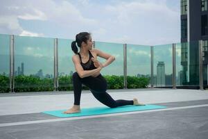 sottile donna praticante yoga su il balcone di sua condominio. asiatico donna fare esercizi nel mattina. equilibrio, meditazione, rilassamento, calma, bene Salute, felice, relax, salutare stile di vita concetto foto