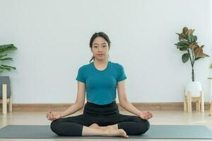 sottile donna praticante yoga su camera di sua condominio o casa. asiatico donna fare esercizi nel mattina. equilibrio, meditazione, rilassamento, calma, bene Salute, felice, relax, salutare stile di vita, dieta, sottile foto