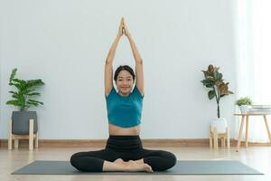 sottile donna praticante yoga su camera di sua condominio o casa. asiatico donna fare esercizi nel mattina. equilibrio, meditazione, rilassamento, calma, bene Salute, felice, relax, salutare stile di vita, dieta, sottile foto