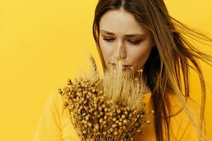 bellissimo ragazza mazzo di secco fiori casuale indossare Sorridi in posa isolato sfondo foto