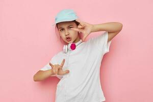 poco ragazza cuffie nel un' bianca maglietta e un' berretto infanzia inalterato foto