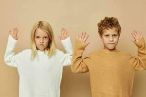 carino elegante bambini abbraccio divertimento in posa amicizia beige sfondo foto