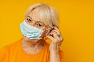 anziano donna nel casuale maglietta medico maschera isolato sfondo foto