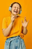 divertente ragazza giallo maglietta cuffie divertimento musica divertimento isolato sfondi inalterato foto