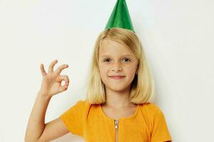 un' ragazza con un' verde berretto su sua testa gesti con sua mani foto