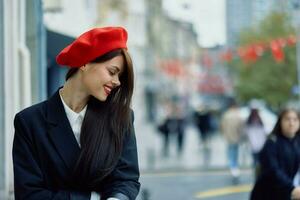 un' bellissimo Sorridi donna con denti passeggiate nel il città contro il fondale di ufficio edifici, elegante alla moda Vintage ▾ Abiti e trucco, autunno camminare, viaggio. foto