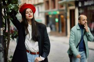 donna modello sta su il strada nel il città nel un' giacca e rosso berretto, cinematico francese moda stile vestiario, viaggio per Istanbul foto