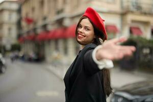 moda donna Sorridi con denti in piedi su il strada nel davanti di il città turista Seguire me elegante Abiti con rosso labbra e rosso berretto, viaggiare, cinematico colore, retrò Vintage ▾ stile, urbano moda. foto