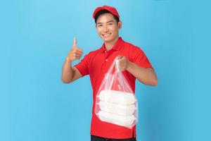sorridente uomo di consegna dipendente in berretto rosso camicia in bianco uniforme in piedi con dando ordine alimentare