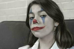 un' adolescenziale ragazza con clown trucco parla di qualcosa emotivamente foto