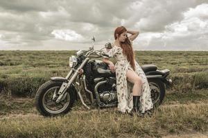 ragazza dai capelli rossi in un abito bianco e stivali insieme a un campo di lavanda moto foto