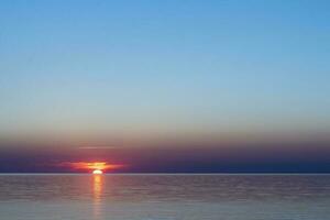 bellissimo rosso tramonto sole su il mare su il superficie di il acqua foto