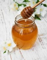 miele e fiori di gelsomino su uno sfondo di legno