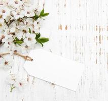 primavera fiore di ciliegio con una carta su uno sfondo di legno foto