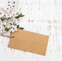 primavera fiore di ciliegio con una carta su uno sfondo di legno foto