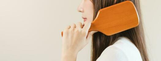 Salute capelli cura, bellezza trucco asiatico donna mano nel Tenere spazzola per capelli e spazzolatura, pettinatura sua lungo dritto capelli nel il mattina routine dopo salone trattamento, acconciatura. isolato su bianca sfondo foto