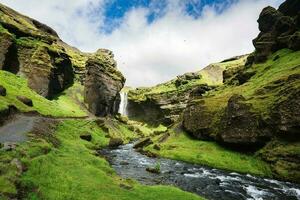 kvernufoss cascata fluente attraverso il verde valle nel soleggiato giorno su estate a Islanda foto