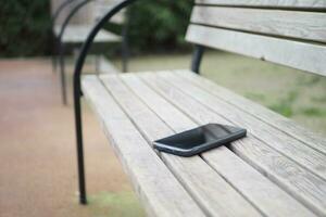 dimenticare smartphone su un' parco panca, perso inteligente Telefono foto