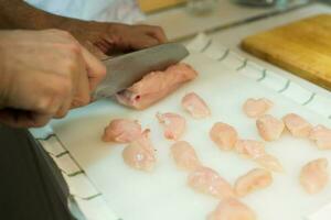 irriconoscibile uomo taglio pollo Seno con giapponese coltello foto