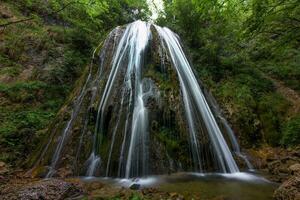 un' cascata nel un' montagna foresta foto