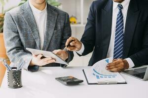 gli analisti finanziari analizzano i rapporti finanziari aziendali su un progetto di investimento di pianificazione di un tablet digitale durante una discussione in una riunione aziendale che mostra i risultati del loro lavoro di squadra di successo. foto