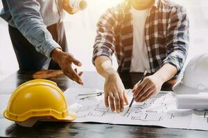 costruzione e struttura concetto di ingegnere Lavorando disegno su planimetria incontro per progetto Lavorando con compagno su modello edificio e ingegneria utensili nel Lavorando luogo, costruzione concetto. foto