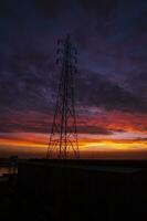 alto voltaggio energia linea Torre con bellissimo cielo a tramonto, azione foto