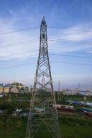 alto voltaggio elettricità pilone con paesaggio urbano e blu cielo sfondo. foto