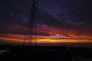 alto voltaggio energia linea Torre con bellissimo cielo a tramonto, azione foto