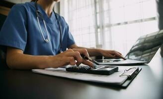 medico Lavorando con il computer portatile computer e scrittura su scartoffie. ospedale sfondo. foto