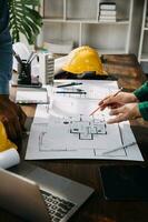 costruzione e struttura concetto di ingegnere Lavorando disegno su planimetria incontro per progetto Lavorando con compagno su modello edificio e ingegneria utensili nel Lavorando luogo, costruzione concetto. foto