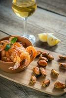 gamberi e cozze fritti con un bicchiere di vino bianco foto