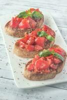 Bruschetta con ciliegia pomodori e basilico foto