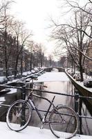 bicicletta e canale ad amsterdam nella neve foto