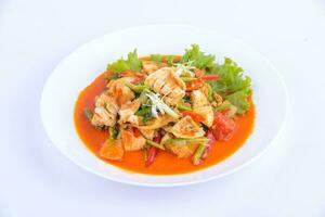 tailandese preferito cibo. agitare fritte calamaro con curry su il bianca piatto. foto
