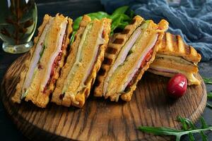 club Sandwich con prosciutto, formaggio, pomodoro e insalata. grigliato Sandwich con secco pomodori pane foto