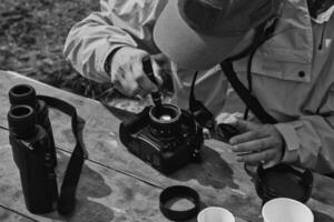 il fotografo pulisce il lenti a contatto a partire dal polvere foto