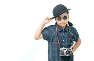 carino poco asiatico ragazza indossare occhiali da sole con Vintage ▾ telecamera isolato foto