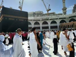 Mecca, Arabia arabia, aprile 2023 - pellegrini a partire dal diverso paesi di il mondo siamo l'esecuzione Tawaf nel il cortile di Masjid al-haram nel mecca durante il giorno. foto