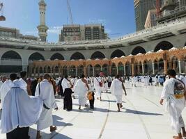 Mecca, Arabia arabia, aprile 2023 - pellegrini a partire dal diverso paesi di il mondo siamo l'esecuzione Tawaf nel il cortile di Masjid al-haram nel mecca durante il giorno. foto