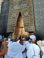 Mecca, Arabia arabia, aprile 2023 - Umra pellegrini a partire dal tutti al di sopra di il mondo raccogliere nel il cortile di Masjid al-haram vicino il porta di il kaaba. foto