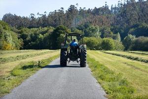 scena di un vecchio trattore visto da dietro su una strada in una zona rurale foto