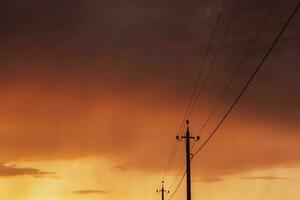 alta tensione energia Linee a tramonto. elettricità distribuzione stazione. elettricità piloni su il sfondo di il cielo foto