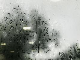 goccia di pioggia sulla finestra di vetro nella stagione delle piogge sullo sfondo della pioggia foto